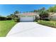 Bright two-car garage with white door and concrete driveway at 7023 Woodside Oaks Cir # 1, Sarasota, FL 34231