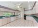 Traditional kitchen featuring white appliances, tile flooring, and white cabinets at 7023 Woodside Oaks Cir # 1, Sarasota, FL 34231