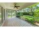 View of the screened lanai with lush landscaping surrounding the property at 7023 Woodside Oaks Cir # 1, Sarasota, FL 34231