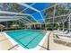Beautiful screened-in pool area with sun loungers and an outdoor seating area, perfect for relaxation at 7023 Woodside Oaks Cir # 1, Sarasota, FL 34231