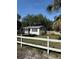Single-story home with a bright red front door and a white fence in the front yard at 7109 28Th E St, Sarasota, FL 34243