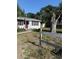 Single-story home with a bright red front door and a fence in the front yard at 7109 28Th E St, Sarasota, FL 34243
