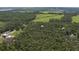 Aerial shot of house surrounded by trees with distant view of a water tower and fields at 7251 Fish Farm Rd, Palmetto, FL 34221