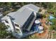 Stunning aerial view of the modern home, showcasing a metal roof, screened deck, manicured garden, and mature trees at 7251 Fish Farm Rd, Palmetto, FL 34221