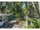 Picturesque backyard with lush greenery, trees, and multiple sheds providing ample storage space at 7251 Fish Farm Rd, Palmetto, FL 34221