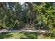 Tranquil backyard setting with lush greenery, shaded seating, and tropical plants at 7251 Fish Farm Rd, Palmetto, FL 34221