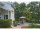 Backyard featuring a charming patio area with outdoor seating, lush landscaping, and mature trees at 7251 Fish Farm Rd, Palmetto, FL 34221