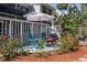 Charming backyard deck with patio furniture, colorful flowers, a flamingo, and a manicured garden at 7251 Fish Farm Rd, Palmetto, FL 34221