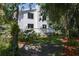 View of backyard featuring a lush, landscaped garden with mature trees, fencing, and a deck area accessible from the home at 7251 Fish Farm Rd, Palmetto, FL 34221