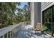 Outdoor balcony featuring railings, a chair, and views of lush trees at 7251 Fish Farm Rd, Palmetto, FL 34221