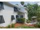 Exterior side view of home with black louvered shutters, manicured landscaping, and outdoor seating area at 7251 Fish Farm Rd, Palmetto, FL 34221