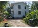 Exterior side view of the home showcasing a well-maintained yard, mature trees, and various yard items at 7251 Fish Farm Rd, Palmetto, FL 34221