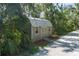 Wooden outbuilding with a metal roof, set among lush greenery and gravel path at 7251 Fish Farm Rd, Palmetto, FL 34221