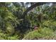 Secluded pond surrounded by tropical foliage, with a pink flamingo decoration at 7251 Fish Farm Rd, Palmetto, FL 34221