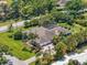 Aerial view of a luxury home with a screened pool, lush landscaping, and a large driveway at 7321 Hemlock Ln, Sarasota, FL 34241