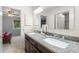Bathroom features a granite countertop, double sinks, brown cabinets, and a tiled shower at 7321 Hemlock Ln, Sarasota, FL 34241
