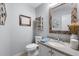 Powder room with light blue walls, decorative mirror, and granite countertop sink at 7321 Hemlock Ln, Sarasota, FL 34241