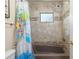 Bathroom with tiled shower, world map shower curtain, and decorative tile at 7321 Hemlock Ln, Sarasota, FL 34241