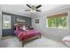A bedroom featuring a dark accent wall, a large window, and ceiling fan at 7321 Hemlock Ln, Sarasota, FL 34241