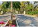 View of the gated community entrance with lush landscaping and mature trees at 7321 Hemlock Ln, Sarasota, FL 34241
