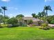 Inviting single-story home with a well-kept lawn, mature palms, and lush tropical landscaping at 7321 Hemlock Ln, Sarasota, FL 34241