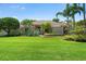 Beautiful single-story home with lush landscaping, mature palm trees, and a well-manicured lawn at 7321 Hemlock Ln, Sarasota, FL 34241