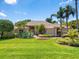 Inviting front yard with lush green lawn and mature landscaping leading to the charming home at 7321 Hemlock Ln, Sarasota, FL 34241