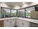 Bright kitchen with a view of the screened lanai and white cabinets, offering a seamless indoor-outdoor experience at 7321 Hemlock Ln, Sarasota, FL 34241