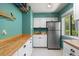 Laundry area with white cabinets, stainless steel fridge, sink, and butcher block countertops at 7321 Hemlock Ln, Sarasota, FL 34241