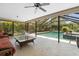 Screened patio with comfortable seating, swing, and view of the pool and greenery at 7321 Hemlock Ln, Sarasota, FL 34241