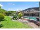 Backyard featuring a screened-in pool with lush landscaping, and a covered porch at 7321 Hemlock Ln, Sarasota, FL 34241
