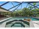 Sparkling pool and spa in screened enclosure, set against a backdrop of mature trees at 7321 Hemlock Ln, Sarasota, FL 34241