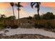 Landscaped backyard featuring white rock ground cover, stone feature, palm trees and wood fence at 7404 13Th Avenue W Dr, Bradenton, FL 34209