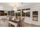 Sunlit dining area with backyard views through large windows, featuring a rustic table and cozy bench seating at 7404 13Th Avenue W Dr, Bradenton, FL 34209