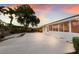 Enclosed patio with multiple windows, a concrete patio, and rock garden with beautiful landscaping at 7404 13Th Avenue W Dr, Bradenton, FL 34209