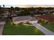 Aerial view of a home with a lush lawn, driveway, and landscaping featuring a white bench and palm trees at 7404 13Th Avenue W Dr, Bradenton, FL 34209