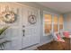Close-up of a front door with wreaths and a small porch with chairs and pillows at 7404 13Th Avenue W Dr, Bradenton, FL 34209