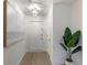 Bright hallway with light wood flooring, white walls, decorative lighting, and a contemporary art piece at 7404 13Th Avenue W Dr, Bradenton, FL 34209