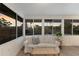 Bright sun room featuring a comfortable white couch and large windows showcasing the backyard at 7404 13Th Avenue W Dr, Bradenton, FL 34209