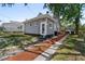Charming gray home featuring a well-maintained lawn, a paved pathway, and mature trees at 766 13Th S Ave, St Petersburg, FL 33701