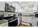 Bright kitchen features white cabinets, stainless steel appliances, and wood-look flooring at 766 13Th S Ave, St Petersburg, FL 33701