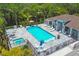 Aerial view of sparkling community pool and spa, surrounded by lush landscaping and lounge area at 8020 Clearwater Ct, Sarasota, FL 34241