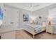 This is a light and airy bedroom with light wood floors, ceiling fan and white furniture at 8020 Clearwater Ct, Sarasota, FL 34241