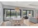 A modern dining room with view of the pool and outdoor space with sliding glass doors at 8020 Clearwater Ct, Sarasota, FL 34241