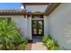 Elegant double front door with glass panels, complemented by lush landscaping and a brick walkway at 8020 Clearwater Ct, Sarasota, FL 34241