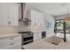 A modern kitchen features white cabinetry, marble countertops, and stainless steel appliances at 8020 Clearwater Ct, Sarasota, FL 34241