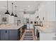 An open kitchen features a navy blue island, marble countertops, stainless appliances and white cabinets at 8020 Clearwater Ct, Sarasota, FL 34241