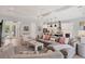 Open-concept living room with a gray sectional sofa, shiplap wall, and a modern kitchen in the background at 8020 Clearwater Ct, Sarasota, FL 34241