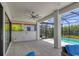 This screened-in patio offers comfortable seating, ceiling fan, and tranquil view of the pool at 8020 Clearwater Ct, Sarasota, FL 34241