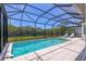 Breathtaking view of a sparkling swimming pool surrounded by lush landscaping and a screened enclosure at 8020 Clearwater Ct, Sarasota, FL 34241
